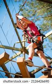 Young Boy Navigating Treetop Ropes Course