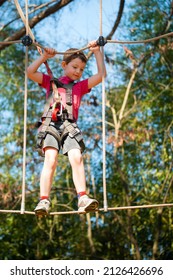 Young Boy Navigating Treetop Ropes Course