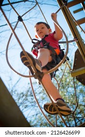 Young Boy Navigating Treetop Ropes Course