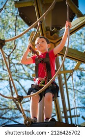 Young Boy Navigating Treetop Ropes Course