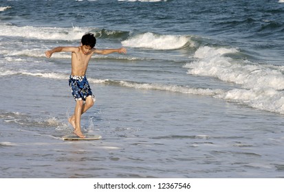 A Young Boy On A Skimboard.