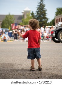 Young Boy At A Parade With An American Flag