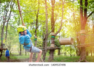 Young Boy Passing The Cable Route High Among Trees, Extreme Sport In Adventure Park In Albania
