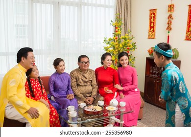 Young Boy Performing In Front Of His Family At The Vietnamese New Year Celebration