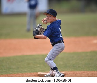 Young boy pitching the ball in a baseball game