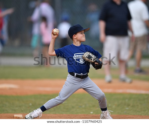 Young boy\
pitching the ball in a baseball\
game