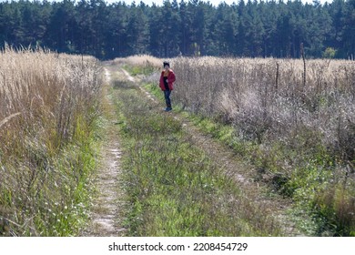 Young Boy Playing In A Field. Boy Running Across The Field With His Hands In Different Directions. Children Fun Games. Nature Leisure With Children Concept.