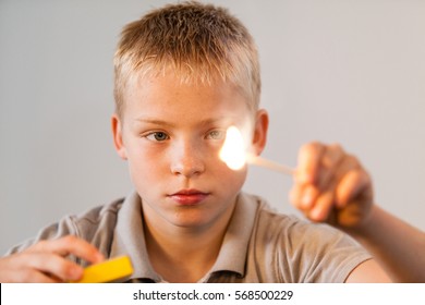 Young boy playing with fire and match sticks