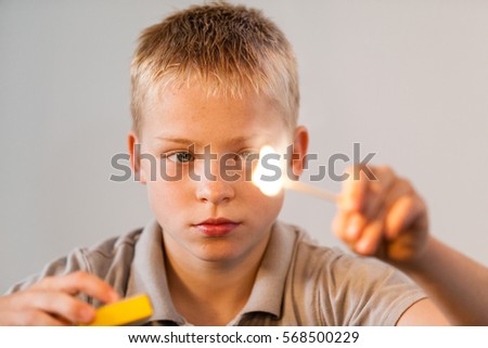 Young boy playing with fire and match sticks