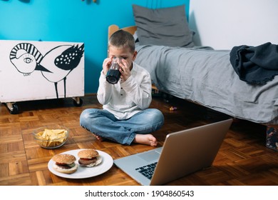 young boy playing games on laptop computer and eating jung food.online games addicted