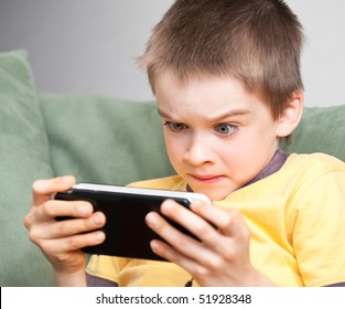 Young Boy Playing Handheld Game Console