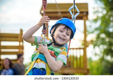 Young boy playing and having fun doing activities outdoors. Happiness and happy childhood concept. Boy swing on rope. - Powered by Shutterstock