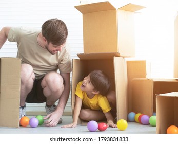 Young Boy Is Playing Hide And Seek With His Dad Inside A Cardboard Box In His Room