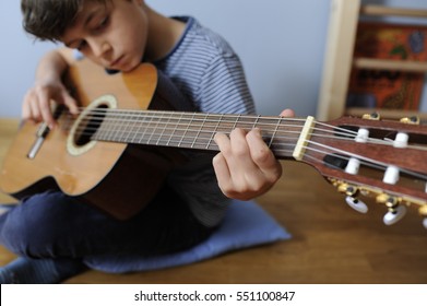 Young Boy Is Playing His Acoustic Guitar