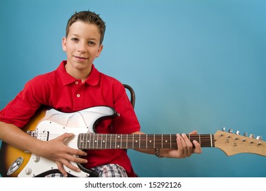 Young boy playing his guitar
