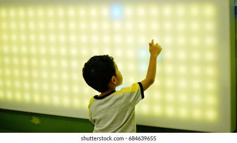 Young Boy Playing With Led Light Interaction Wall