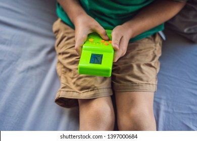 Young Boy Playing Old School Portable Game Console, Electronic Retro Pocket Toy With Monochrome Display