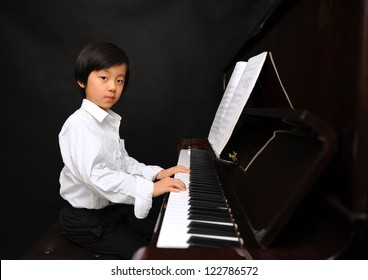 Young Boy Playing Piano  (isolated On Black Background)