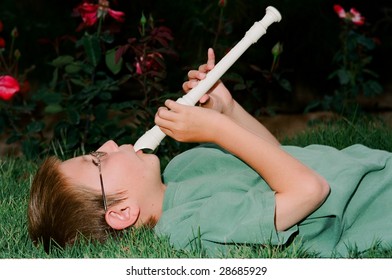 Young Boy Playing A Recorder Musical Instrument