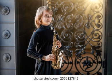 A young boy is playing a saxophone in front of a wrought iron gate. Concept of creativity and passion for music, as the girl is fully engaged in her performance - Powered by Shutterstock