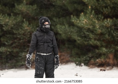 Young Boy Playing In Snowy Winter Wonderland Wearing Snow Suit