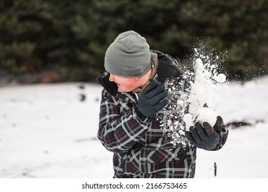 Young Boy Playing In Snowy Winter Wonderland Snowball Fight