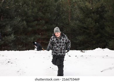 Young Boy Playing In Snowy Winter Wonderland Snowball Fight