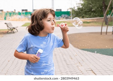 Young boy playing with soap bubbles outdoors in a park