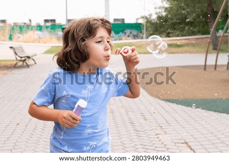 Young boy playing with soap bubbles outdoors in a park
