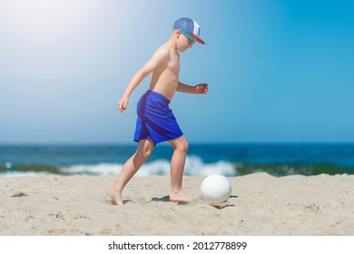 Young Boy Playing Soccer On Beach. Summer Sport Concept
