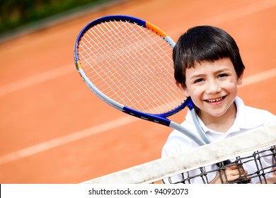 Young boy playing tennis at a clay court