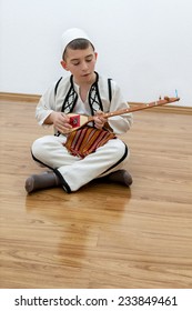 young boy playing traditional string instrument