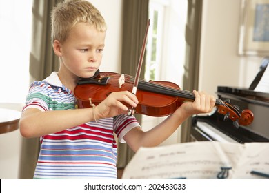 Young Boy Playing Violin At Home