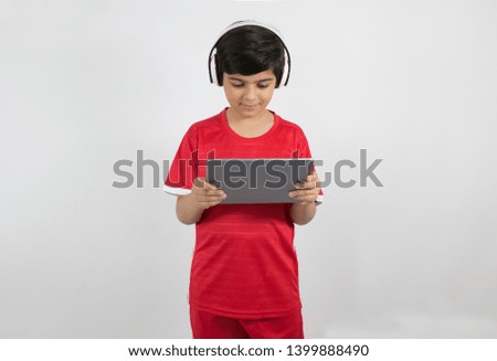Young boy plays with his tablet isolated on white background