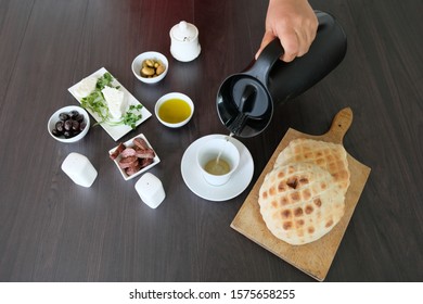 Young Boy Pouring Tea To Drink With His Healthy Breakfast