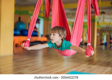 Young boy practicing aerial yoga in gym. Lifestyle. Kids yoga concept - Powered by Shutterstock