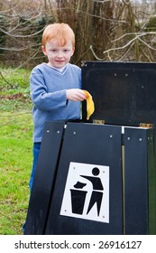 Young Boy Putting Waste Food Scraps Into A Bin