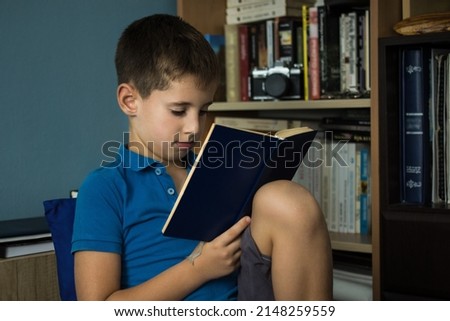 Young boy reading book at home library