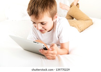 Young Boy Reading Book on Tablet Device