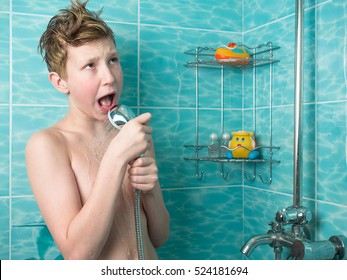 Young boy with red hair and naked torso holding a watering can shower and sings on the background of blue tiles and bottles of shampoo
