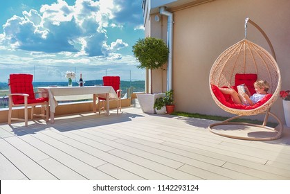 young boy relaxing in hammock on modern rooftop patio, home terrace