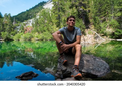 Young boy relaxing on a lake during a mountain trekking. Adventurous trip