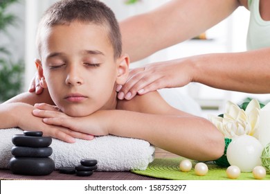  young boy  relaxing in spa. stone massage.  - Powered by Shutterstock