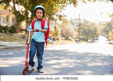 Young Boy Riding Scooter Along Street To School - Powered by Shutterstock