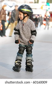 young boy rollerskating in city