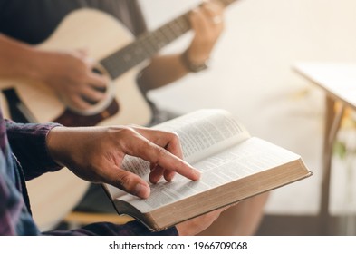 A Young Boy Sat And Read The Bible While His Friend Played Guitar At Church When He Worshiped God. A Small Group Of Christians Or A Concept In A Church At A Church