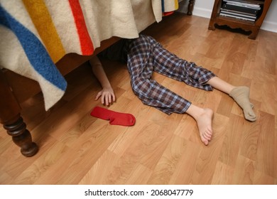 Young Boy Searching For His Lost Sock Under The Bed