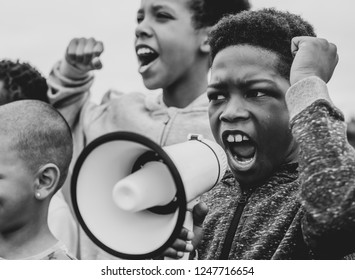 Young boy shouting on a megaphone in a protest - Shutterstock ID 1247716654