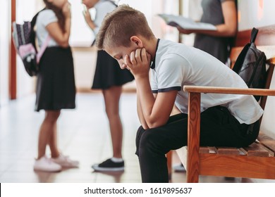 Young boy sitting alone on a bench during break at school - Shutterstock ID 1619895637