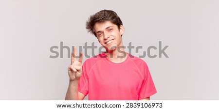 young boy smiling and looking friendly, showing number three or third with hand forward, counting down